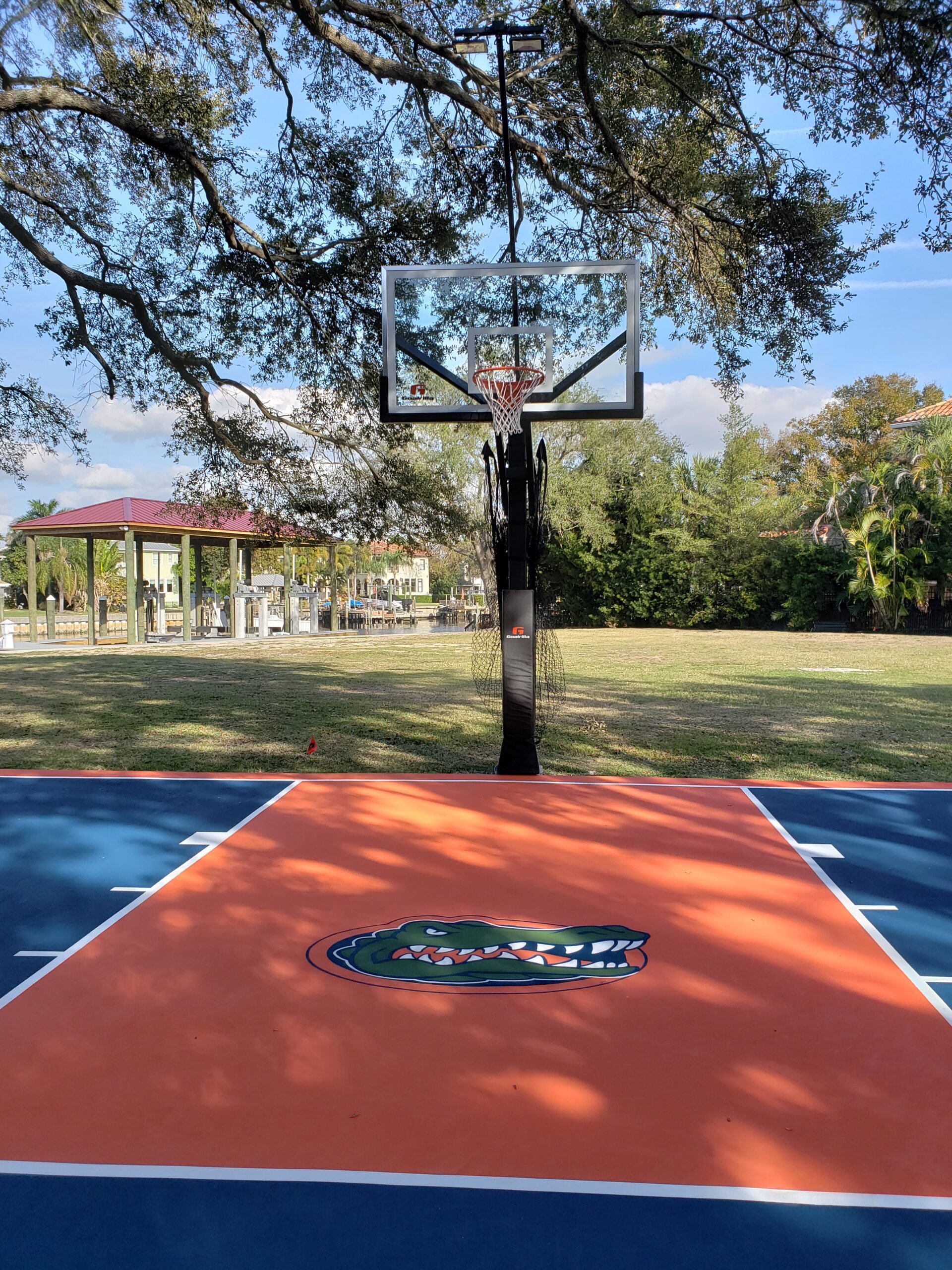 Basketball goal over an orange and blue court painted with a Gators logo