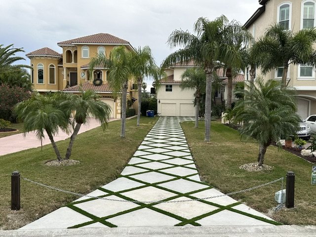 Diagonal concrete paver walk with turf joints leading to a home
