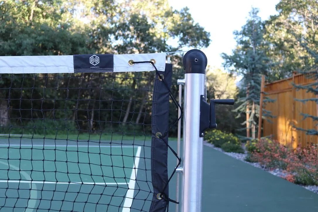 Pickleball net system with aluminum post set on a teal court