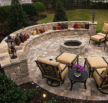 Circular paver patio with a stone seating wall and fire pit