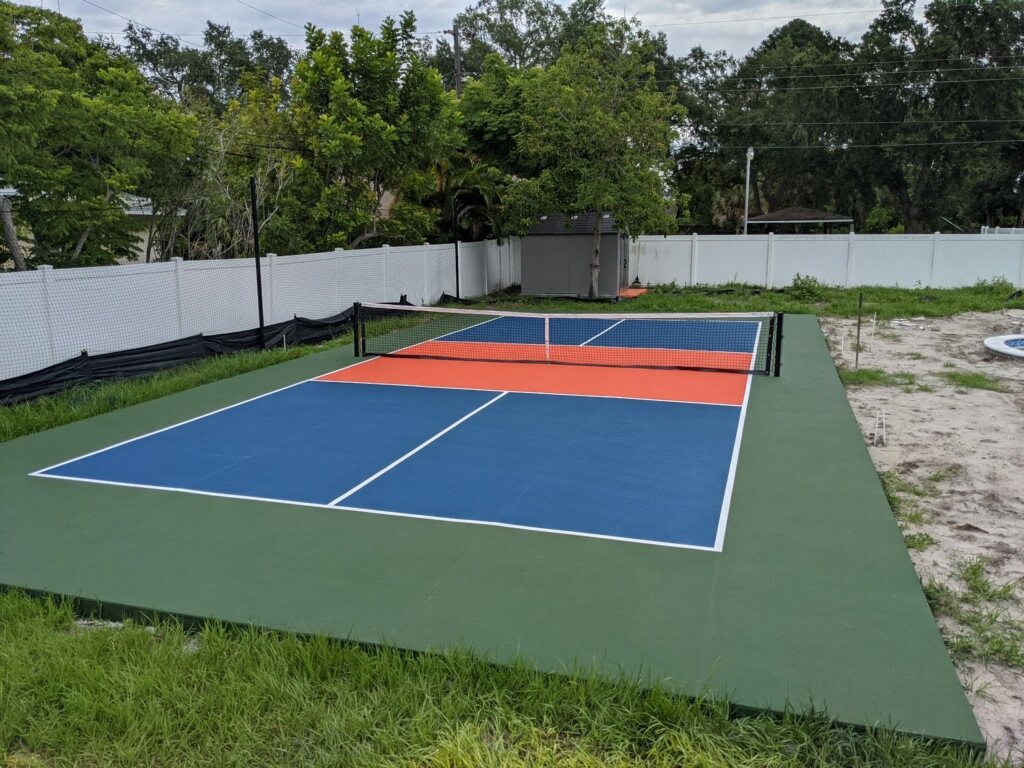 Pickleball court with a red kitchen zone and permanent net