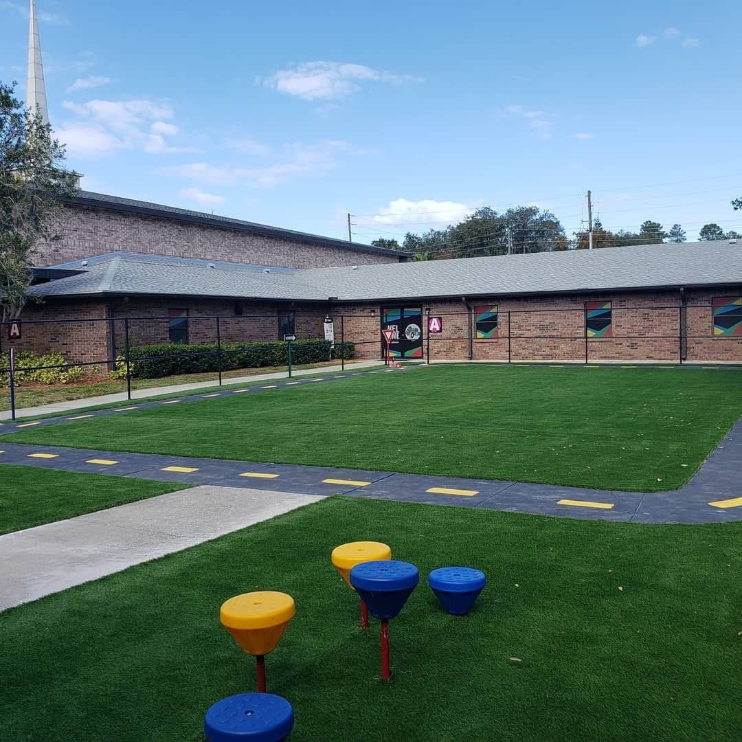 School courtyard turf with a painted path and colorful stepping stools