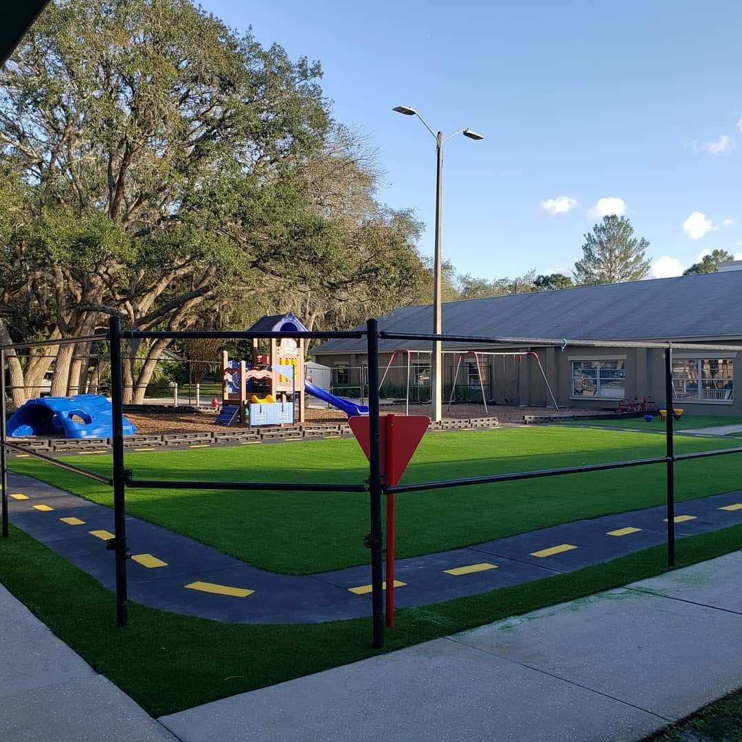 School play yard with turf, a painted trike track and playground