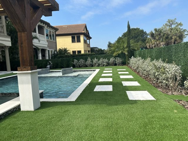 Turf lawn with inset pavers leading to a raised pool