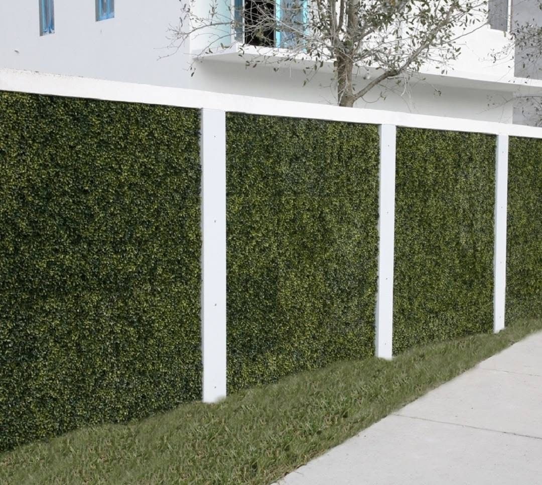 Artificial hedge privacy panels mounted between white posts